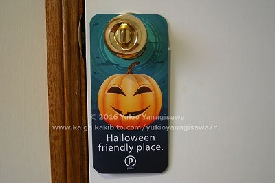 笑っているハロウィン用カボチャの絵の札。ドアノブにかかっています。
