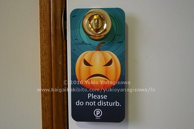 怒っているハロウィン用カボチャの絵。ドアノブにかかっています。