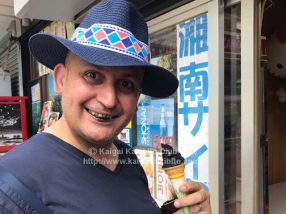 竹炭入りの黒いソフトクリームを食べる人