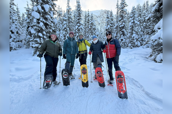 Five people posing in the snow
